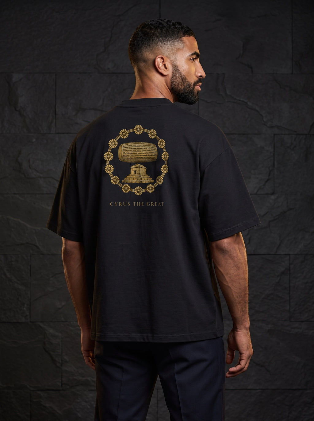 Aryamehr Kyros der Große T-Shirt schwarz, 425 g/m² Oversize – großer Rückendruck in Gold, getragen von einem Mann