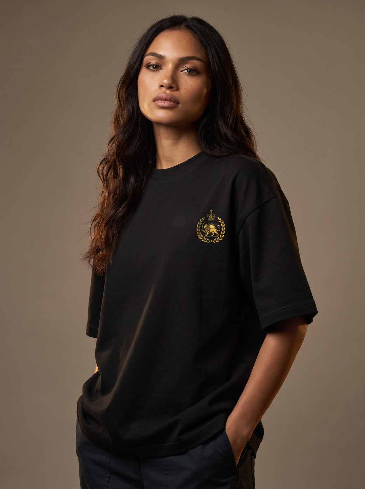 Aryamehr Kyros der Große T-Shirt schwarz – Vorderseite mit kleinem Löwe-und-Sonne-Brustmotiv, getragen von einer Frau