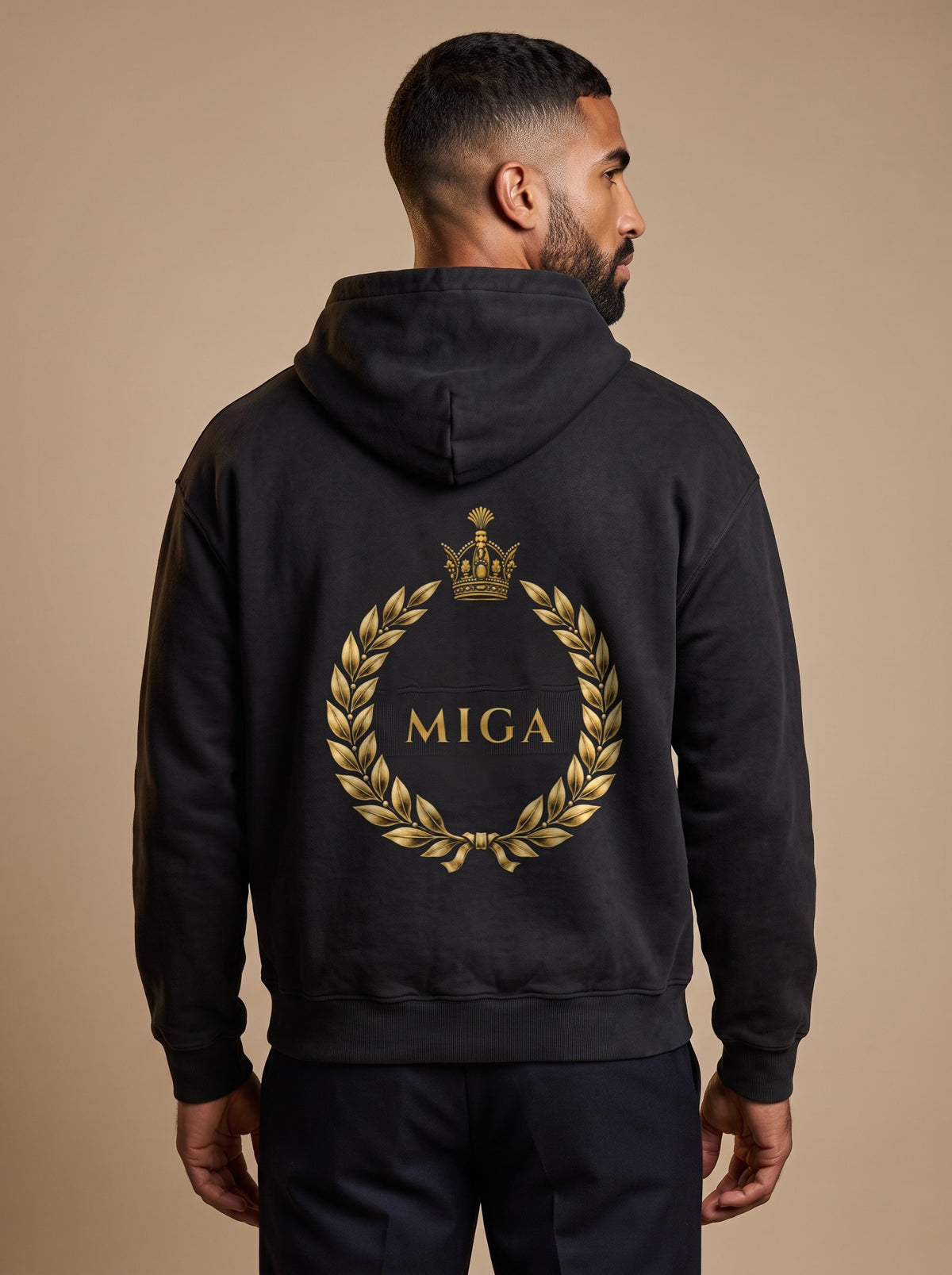 Aryamehr MIGA Hoodie schwarz, 440 g/m² Oversize – großer Rückendruck in Gold, getragen von einem Mann