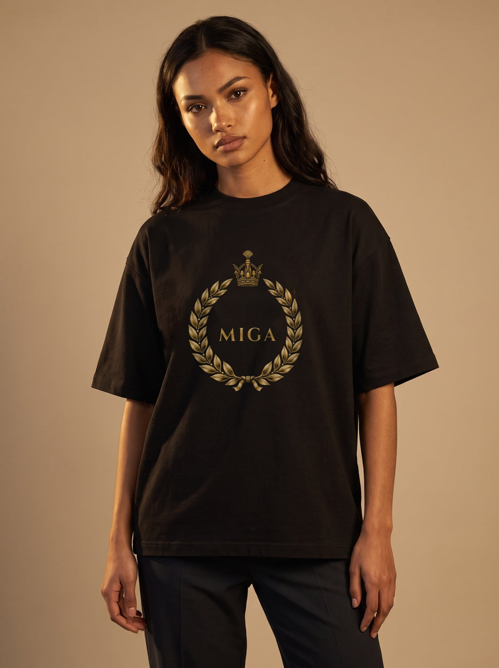 Aryamehr MIGA T-Shirt schwarz, 425 g/m² Oversize – großer Frontdruck in Gold, getragen von einer Frau