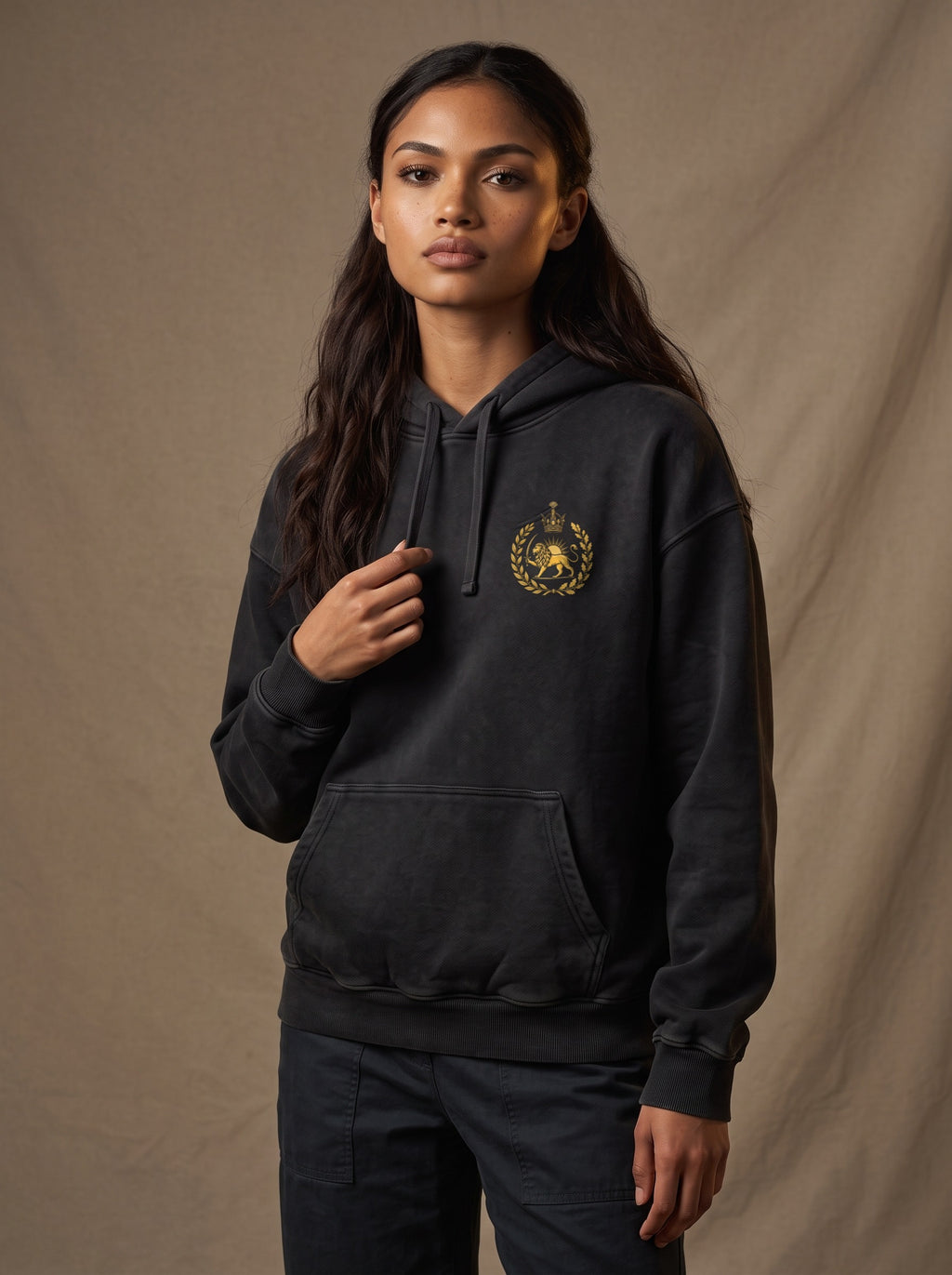 Aryamehr Persepolis Hoodie schwarz, Oversize – Vorderseite mit kleinem Löwe-und-Sonne-Brustmotiv, getragen von einer Frau