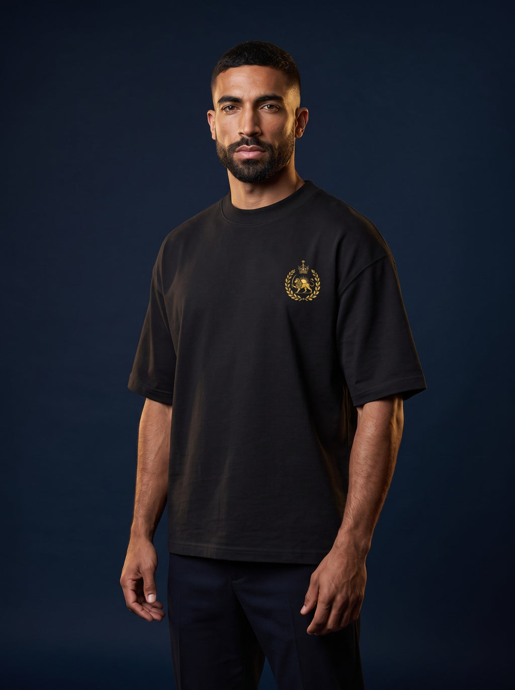 Aryamehr Persepolis T-Shirt schwarz, Oversize – Vorderseite mit kleinem Löwe-und-Sonne-Brustmotiv, getragen von einem Mann