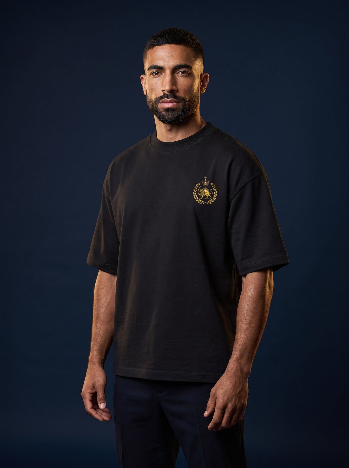 Aryamehr Persepolis T-Shirt schwarz, Oversize – Vorderseite mit kleinem Löwe-und-Sonne-Brustmotiv, getragen von einem Mann